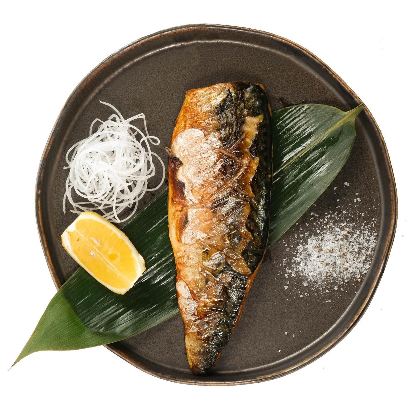 Grilled mackerel on a leaf with lemon